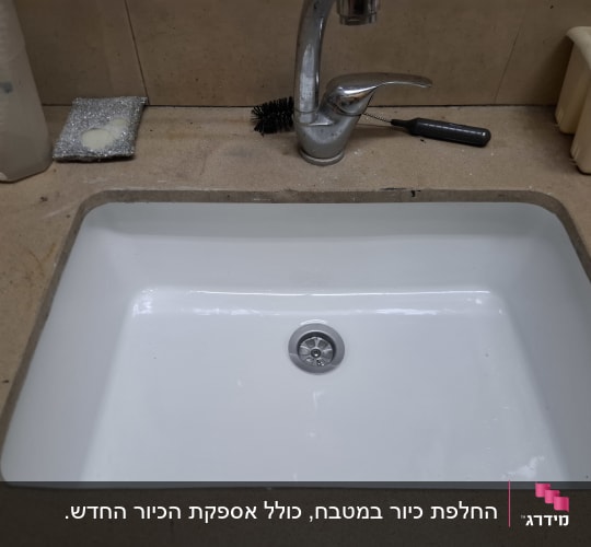 כיור מטבח עם ברז וכלים לניקוי